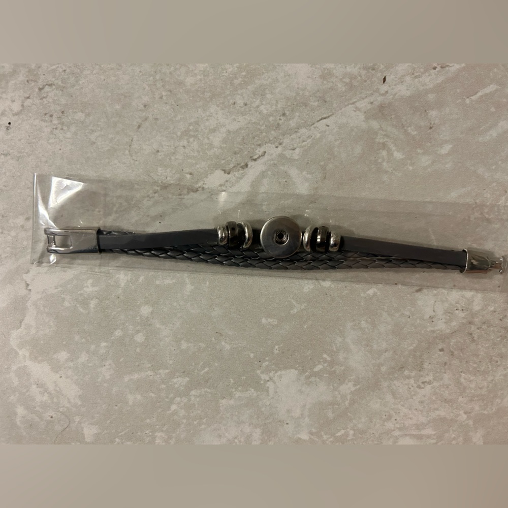 Leather style black bracelet with silver details.
